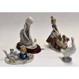 Two Lladro figures of young girls with puppies along with two Nao figures