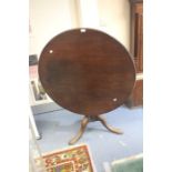 A George III mahogany tilt top table, circa 1800, circular top above a turned column on tripod