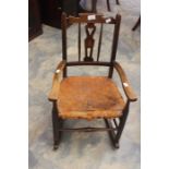 A 19th century oak rush seated with leather lattice pattern child's rocking chair, turned supports.
