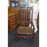 A 17th Century revival carved oak hall chair, crown and scroll carving at the top, back rest and
