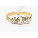 An 18ct gold and diamond three stone ring, central old cut approx 0.75ct, flanked by two smaller