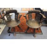 A pair of late 19th Century oak swivel, Black Forest style oak captains chairs on lions paw legs,