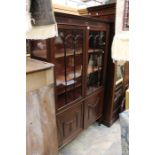 An early 20th century mahogany display cabinet, moulded cornice above a three tier shelves with