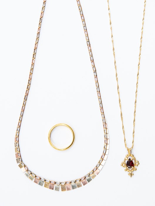 A 9k three colour gold fringe necklet, approx 3gms; a 9ct pendant set garnet on fine link chain,