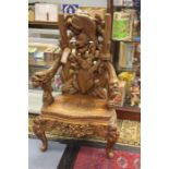 An Eastern origin hand carved armchair with carved grotesque figures