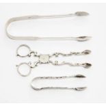A pair of white metal early 19th Century sugar tongs, together with two other silver nips, Newcastle