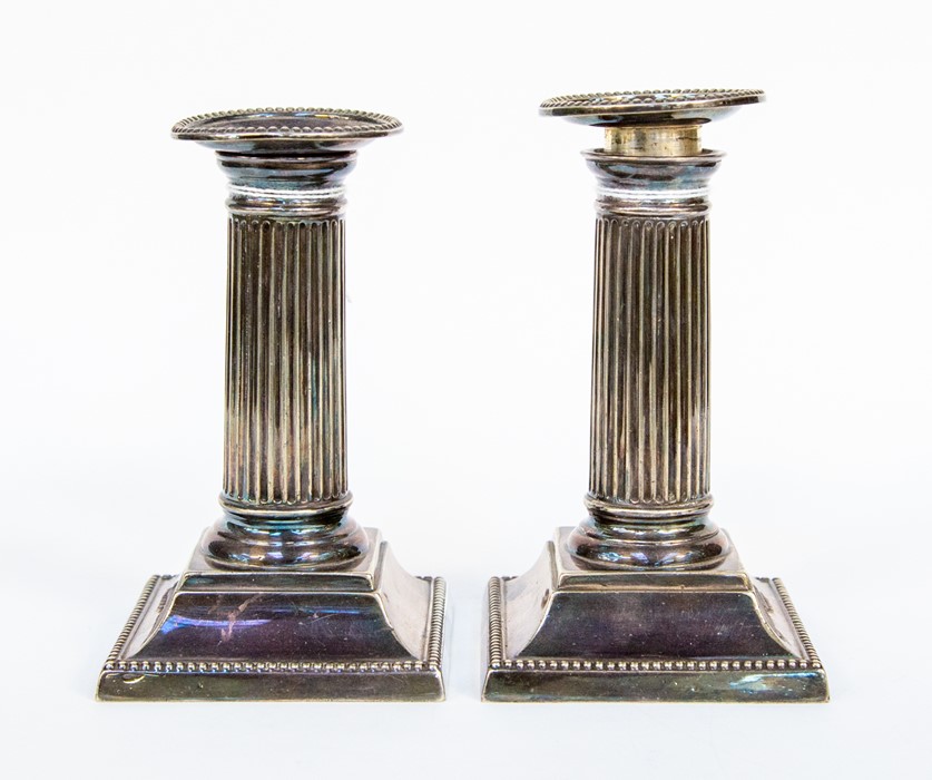 A pair of silver plated candlesticks, beaded border