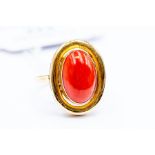 A coral set dress ring, set with an oval coral, size approx. 15mm x10mm, rub-over set with a rounded