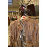 An early 1960's honey blonde mink coat, collarless, cathedral sleeves, into a tight waistband, (