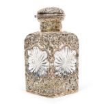 A cut glass cologne bottle, with silver casing, Rococo style, silver hinged cap and original