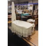 A Victorian oak moses basket with linen.