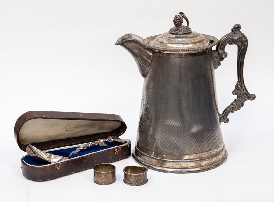 A large claret, silver plated Victorian jug with American cased grape spoon and silver napkin rings