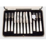 A boxed set of six fruit knives and forks with silver blades and tines, mother of pearl handles,