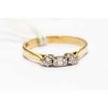 A 9ct gold three stone diamond ring, set central emerald cut with two round brilliant cut