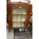 An early 20th Century mahogany display glazed cabinet on short cabriole legs on claw feet.