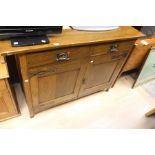 An oak sideboard in the Art Nouveau style on square tapered legs. Two Drawers over double door