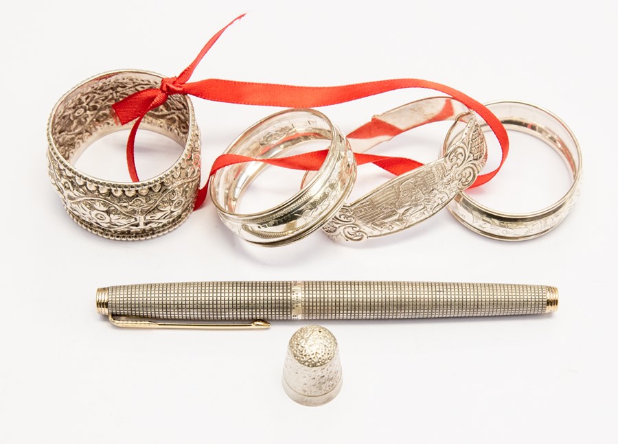 Four various silver napkin rings, a sterling silver Parker fountain pen and a silver thimble (6)