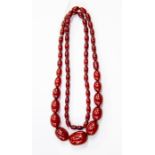 A cherry amber bead necklace, comprising graduated oval beads, the largest measuring approx.  30mm x