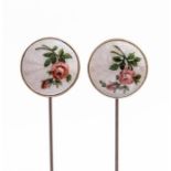 A pair of silver and enamel hat pins, the white guilloche enamel painted with roses