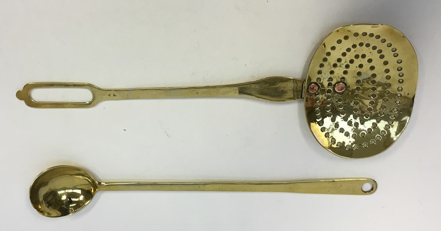 An 18th century brass dairy skimmer, two copper rivers secure the handle to the pan, L.43 cms (