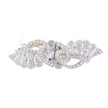 A diamond set double-clip brooch, circa 1950's, comprising stylised petal wing and scroll motifs,