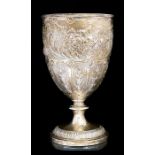 A late Victorian large goblet, the body profusely chased with scrolling flowers and foliage above