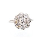 A diamond set flower head cluster ring, the principal collet-set round old-cut diamond approx 0.