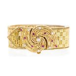 A ruby and diamond 18ct gold fancy link woven bracelet, the buckle style swirl clasp scattered