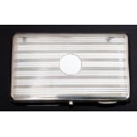 A George V large silver cigarette case, engraved with striated pattern and vacant circular