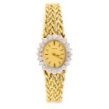 Genève- A  ladies diamond set 14ct gold Genève watch, the oval gold tone dial with a diamond claw