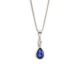 A sapphire and diamond 9ct white gold pendant, comprising a rub-over set, pear cut sapphire