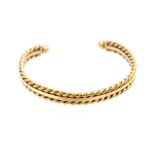 A 9ct gold torque bangle, comprising two rope twist rows either side of a flat central row with ball