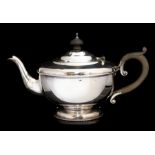 An Art Deco silver tea pot, plain circular with beaded rim, fruitwood C-scroll handle and mushroom