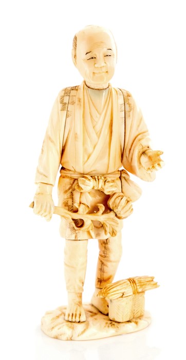 A Japanese ivory okimono of a woodsman, Meiji period, 1868-1912, carved standing holding a branch