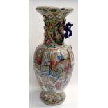 A Famille Rose Canton vase depicting interior scenes of important family, chrysanthemums,