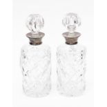 A pair of Elizabeth II silver mounted glass decanters and stoppers, the plain silver collars are