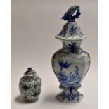 Two blue and white tin glaze items comprising: a large pot and cover showing a couple in a garden,