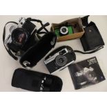 A Canon SLR AT-1 with booklet, Olympus TRIP 35, a pair of sport binoculars 16 x 25, Canon