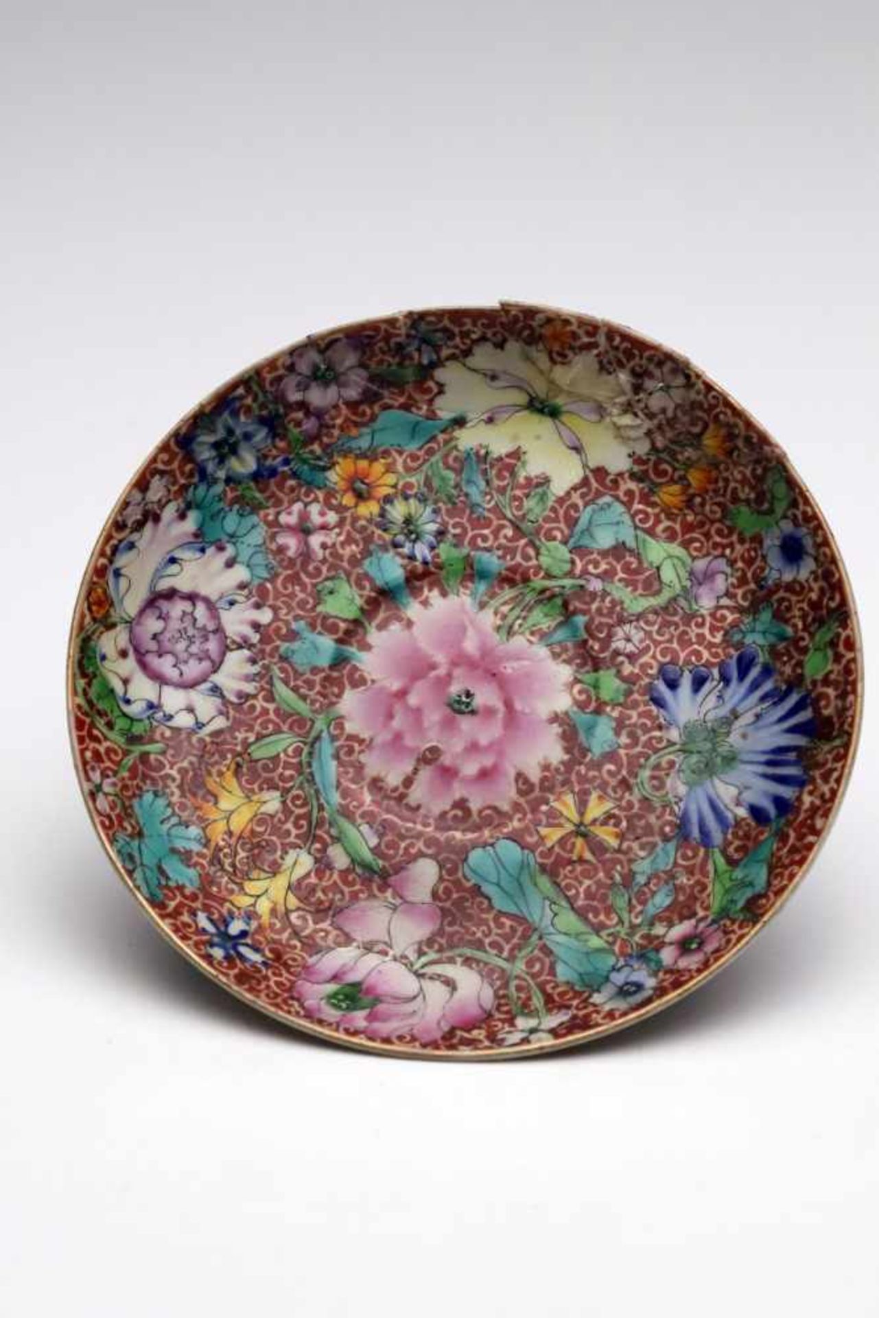 PLATEporcelainChina, 18th century,Size: 3 cm x 14 cmA repaired plate with red background colour