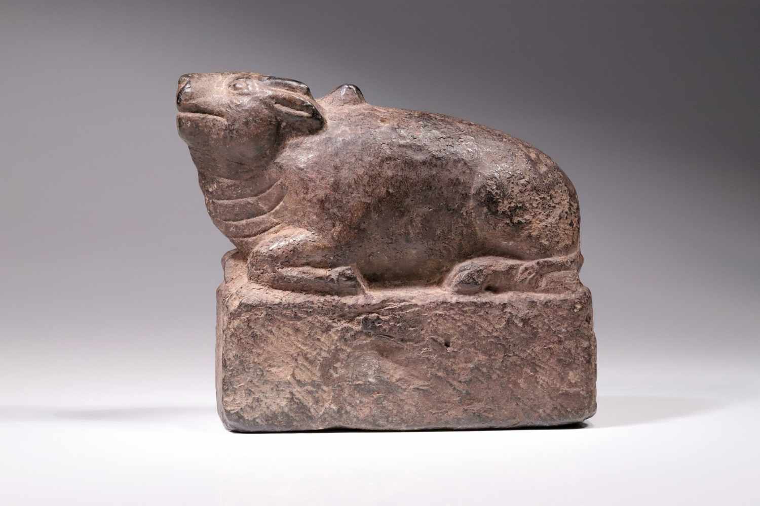 NANDIgrey stone,Nepal, 14th century,Size: 14 cm x 17 cmNandi resting on a square base, the face with