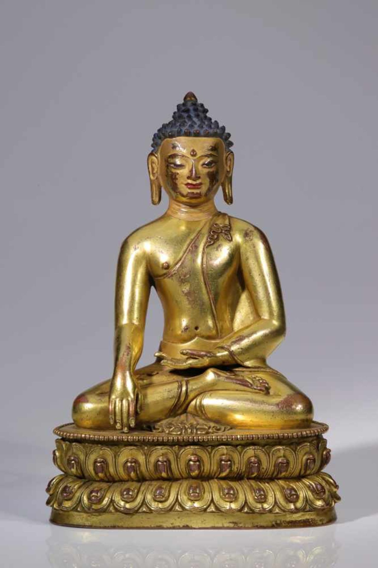 SITTING BUDDHAbronze firegilt, face gold paintedTibet, 17th centurySize: 17, 5 cmBuddha seated on