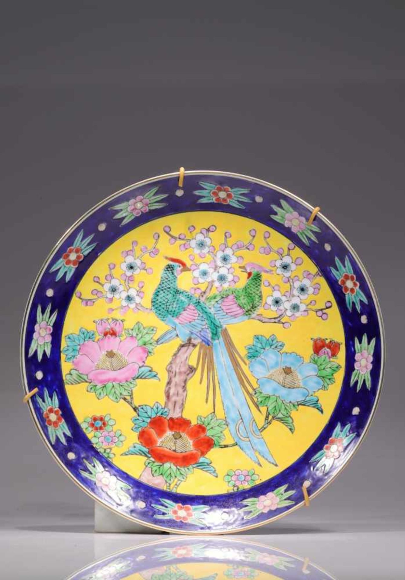 ROUND YELLOWISH PLATEporcelain,China, 19th century,Size: 31 cmPair of blue and green parrots on