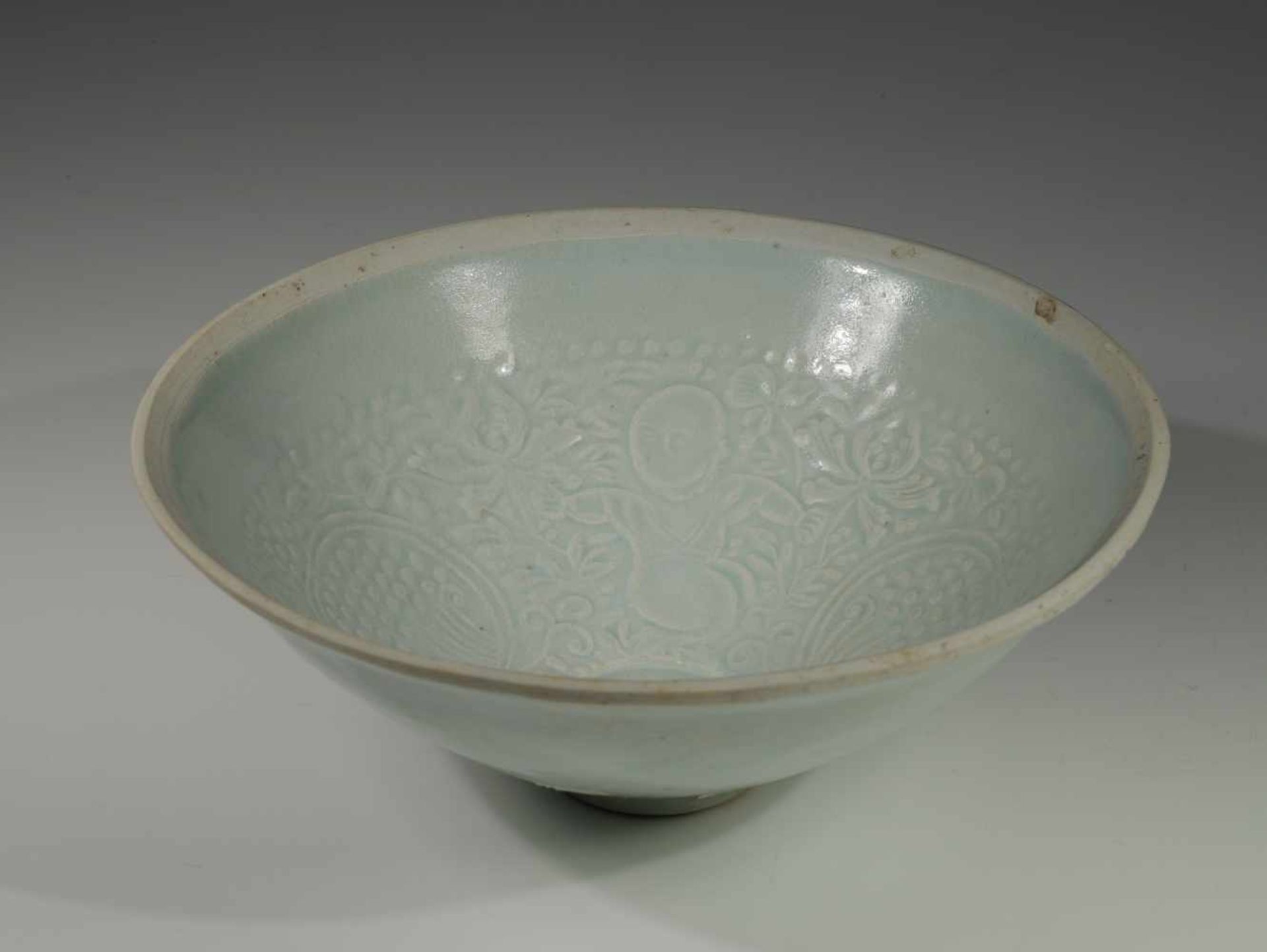 FINE AND RARE PORCLAIN BOWLBeige glazed, inside with floral motives, outside China, 12th - 13th