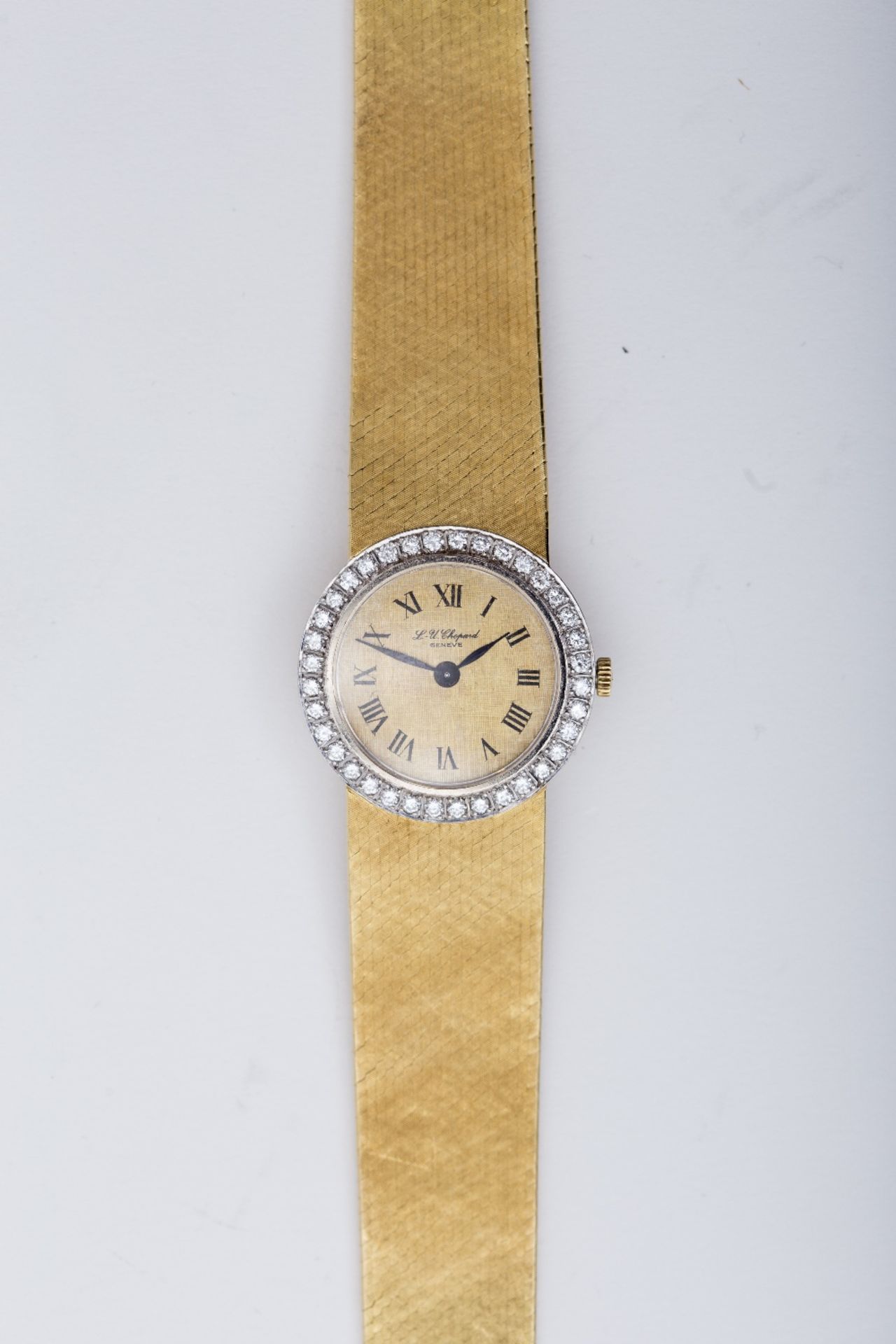 Chopard Lady's watch: 18 kt yellow gold with round dial, Roman numerals, framed with brilliants.