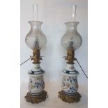 Pair of kerosene lamps; Polychrome porcelain with golden highlights, electric wiring. HT: 72 cm