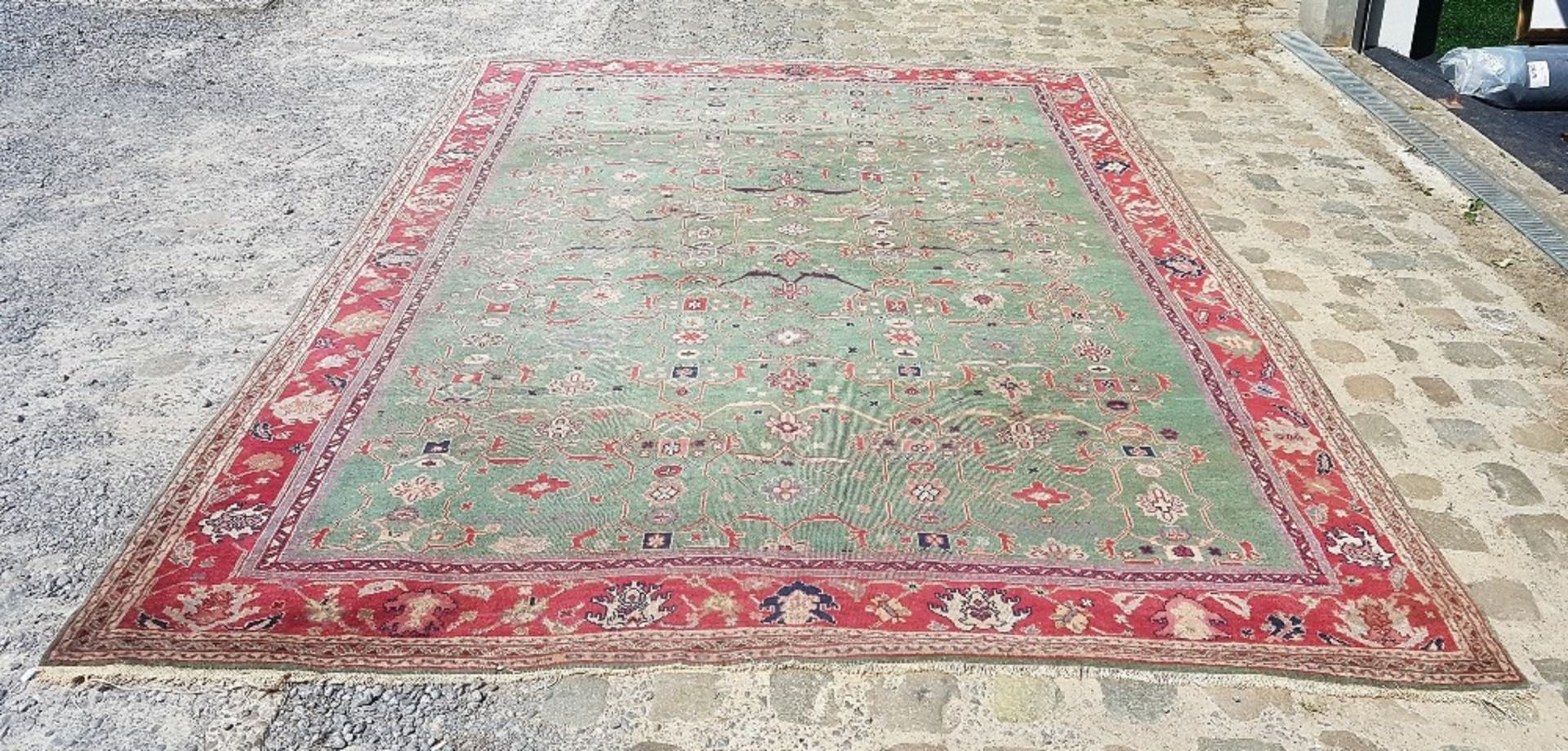 Middle EastRug; Wool, with green ground and red décor. Used condition. 348 x 260 cm