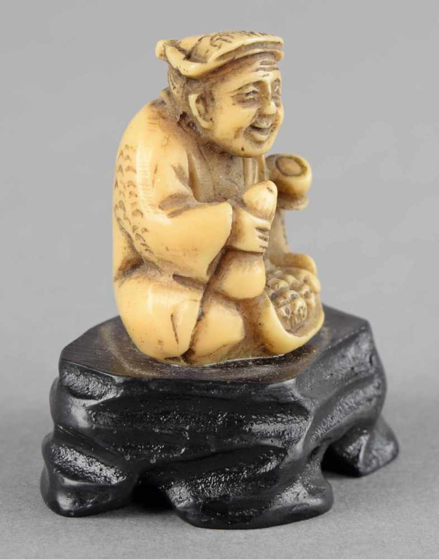 Okimono Bein vollrund geschnitzt, Mann in sitzender Pose ein gegürtetes Gewand tragend, in den - Bild 3 aus 4