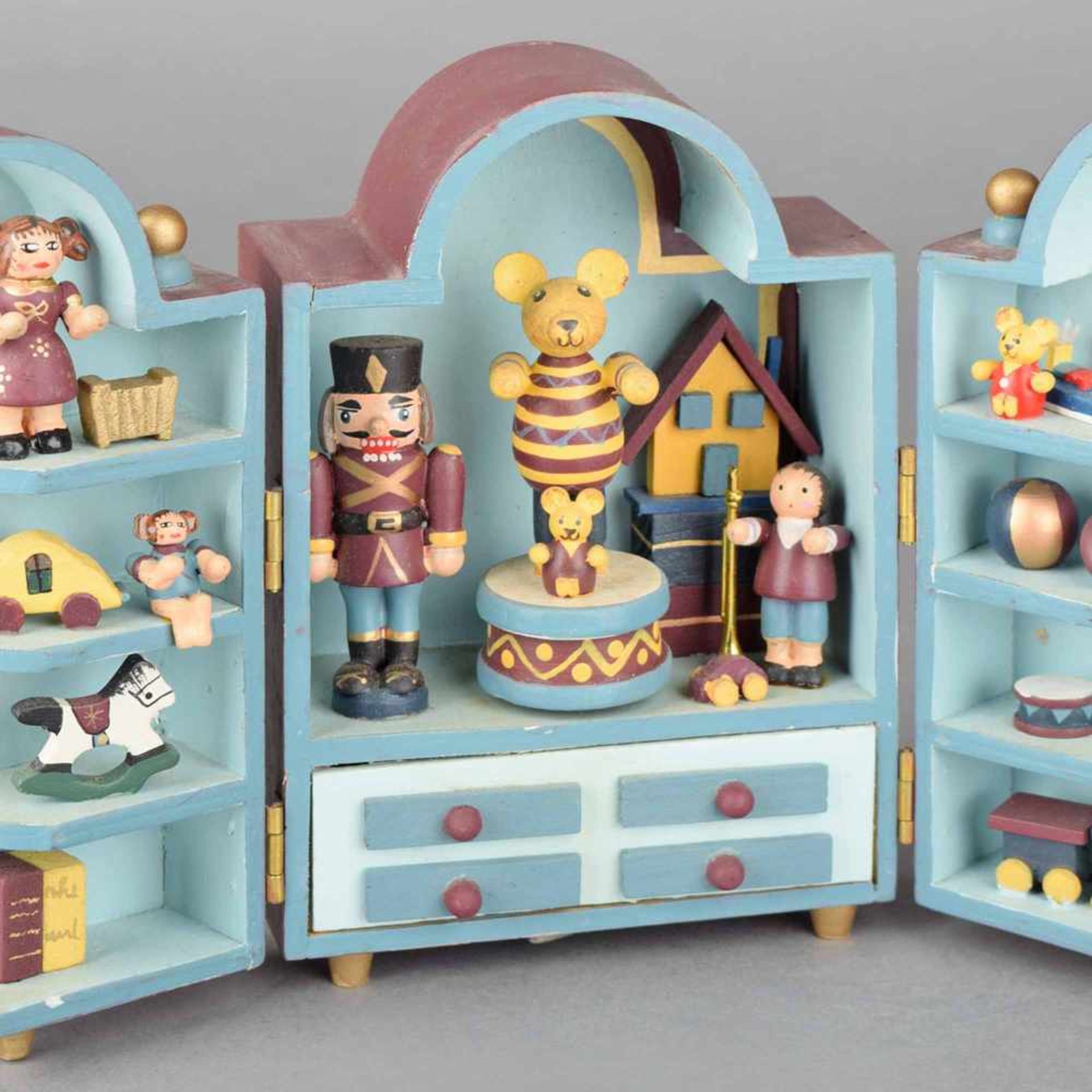 Spieldose Holz farbig bemalt, gestaltet in Form eines aufklappbaren Schrankes mit Spielzeug