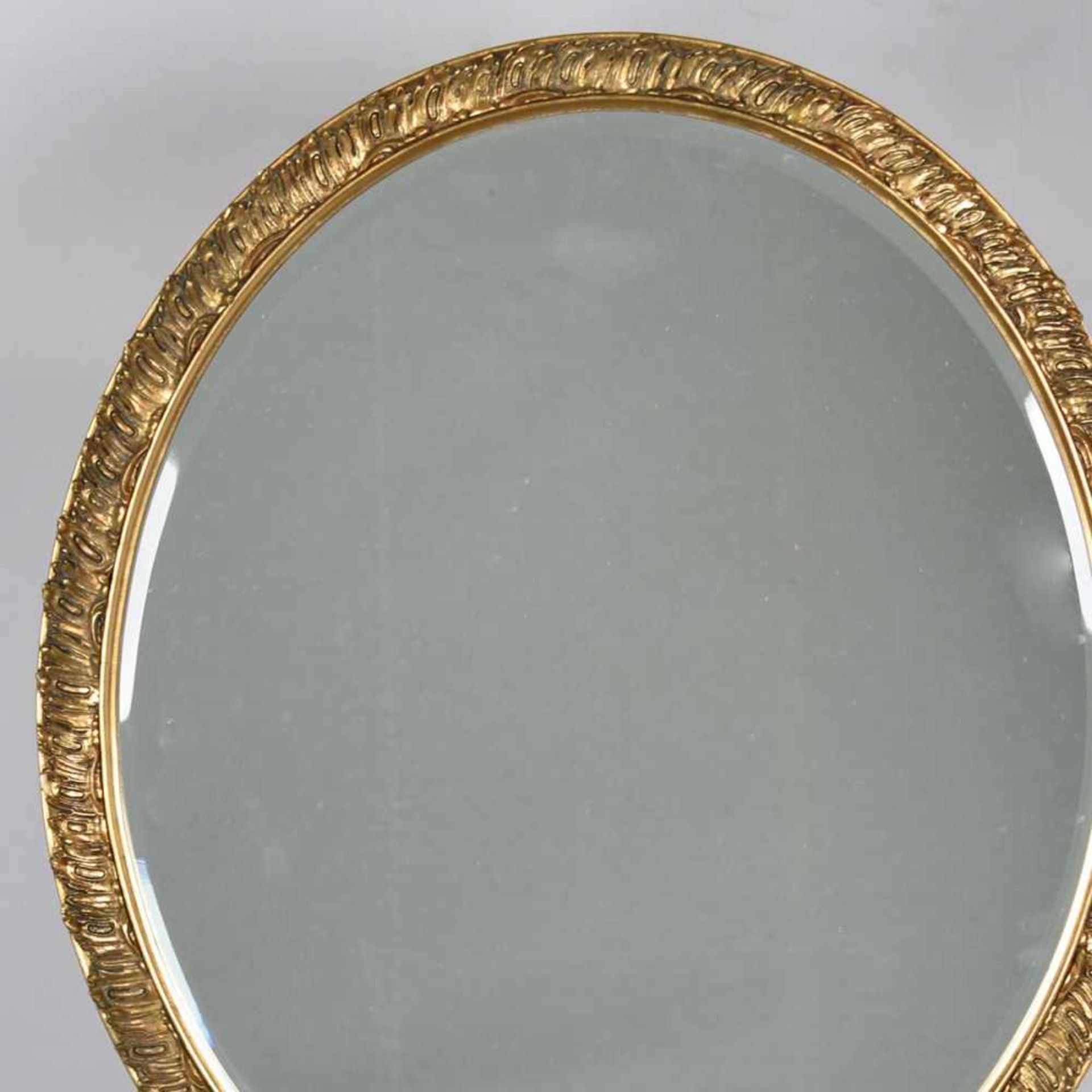 Wandspiegel ovale facettierte Spiegelfläche in goldfarbener Rocaillenrahmung, ca. 66,5 x 56,5 cm,