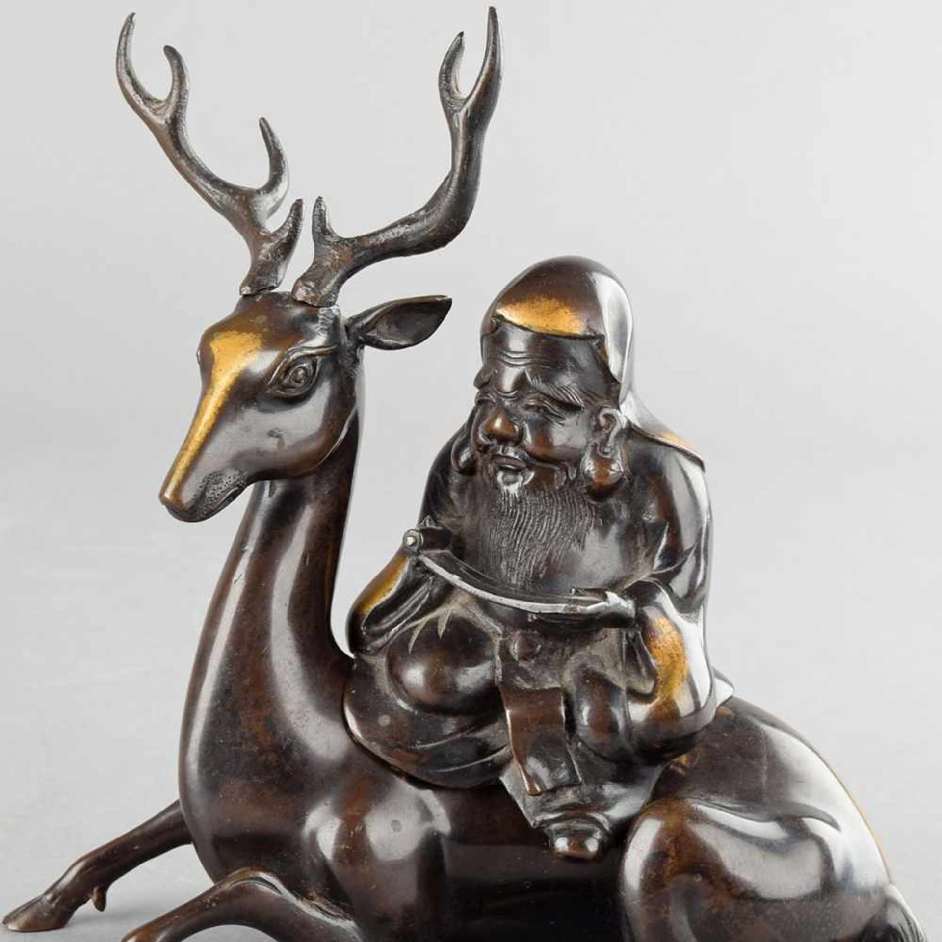 Asiatischer Glücksgott Bronze dunkelbraun patiniert, bärtiger Jurojin mit Schriftrolle auf einem